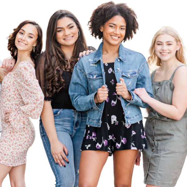 Zes jonge vrouwen staan op een rij en glimlachen naar de camera. Ze zijn gekleed in casual lente- of zomeroutfits tegen een effen, lichte achtergrond.