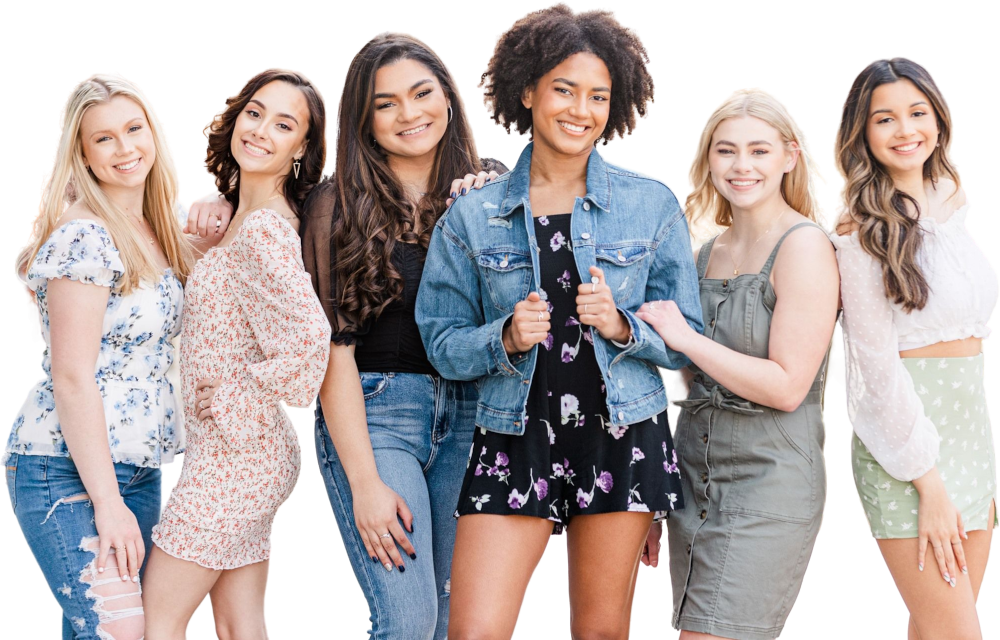 Zes jonge vrouwen staan op een rij en glimlachen naar de camera. Ze zijn gekleed in casual lente- of zomeroutfits tegen een effen, lichte achtergrond.
