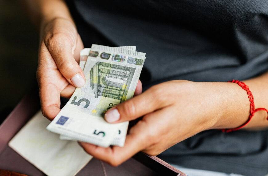 Twee handen houden een paar 5-Euro biljetten beet.